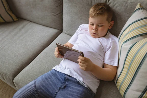 Niño Caucásico Usando Tableta Digital Sentado Sofá Casa Infancia Tecnología —  Fotos de Stock