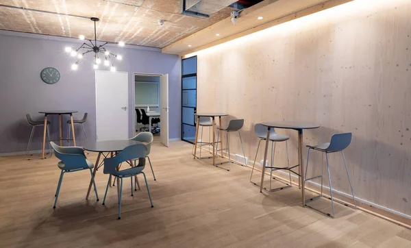照明付きオフィスのハードウッドフロアのテーブルの周りに配置された空の椅子 事務所 — ストック写真