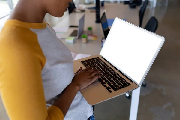 非洲裔美国女商人的中间阶层穿着休闲装 使用的是带有办公空间的笔记本电脑 无线科技及办公室 — 图库照片