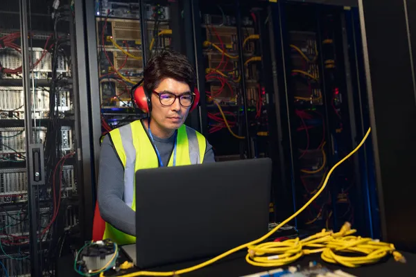 Aziatische Mannelijke Ingenieur Draagt Oordopjes Met Behulp Van Een Laptop — Stockfoto