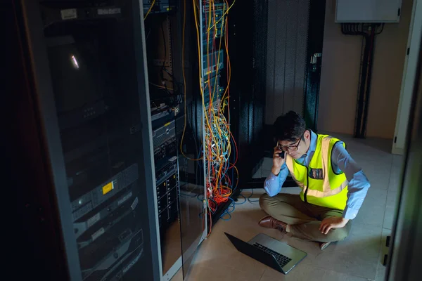 Azjatycki Inżynier Laptopem Rozmawiający Smartfonie Podczas Inspekcji Serwerowni Koncepcja Zarządzania — Zdjęcie stockowe