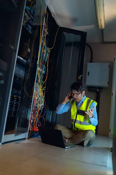Bilgisayarlı Asyalı Erkek Mühendis Bilgisayar Sunucu Odasını Incelerken Akıllı Telefondan — Stok fotoğraf