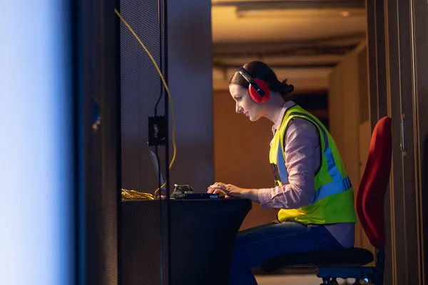 Caucasian Female Engineer Wearing Ear Plugs Using Laptop Computer Server — Stock Photo, Image