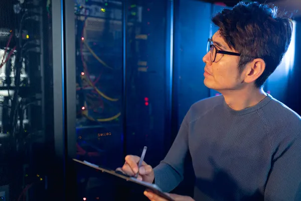 Ingeniero Masculino Asiático Escribiendo Portapapeles Mientras Inspecciona Sala Servidores Computadoras — Foto de Stock