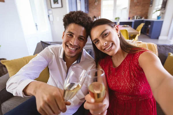 Portrait Smiling Young Biracial Couple Champagne Flutes Taking Selfie Home — стоковое фото