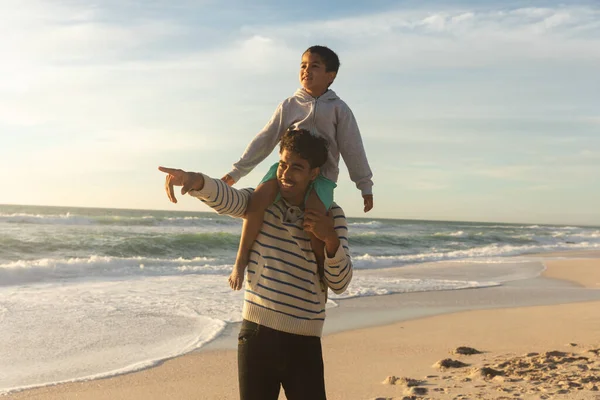 Feliz Padre Biracial Señalando Hijo Mientras Lleva Hombros Playa Contra —  Fotos de Stock