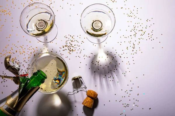 俯瞰瓶装香槟酒倒入玻璃杯盖住白色背景的意大利面的情景 庆祝活动和带有复制空间的聚会 — 图库照片