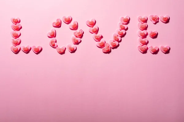 Love Text Made Heart Shaped Candies Pink Background Copy Space — Stock Photo, Image