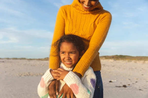Sorridente Giovane Donna Biraciale Piedi Dietro Figlia Guardando Spiaggia Contro — Foto Stock