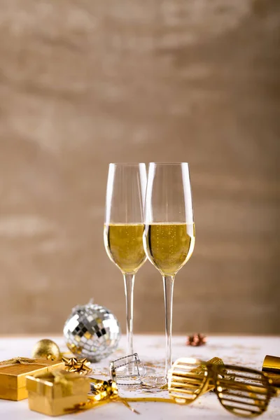 用金黄色的新奇眼镜和桌上的礼品盒把香槟长笛包起来 庆祝活动和带有复制空间的聚会 — 图库照片