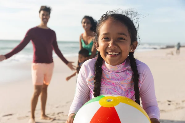 Retrato Una Chica Birracial Sonriente Sosteniendo Pelota Con Familia Playa —  Fotos de Stock