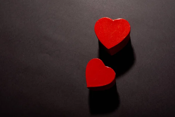 黒い背景にコピースペースによって影と2つの赤いハート型のオーバーヘッドビュー 愛とバレンタイン — ストック写真