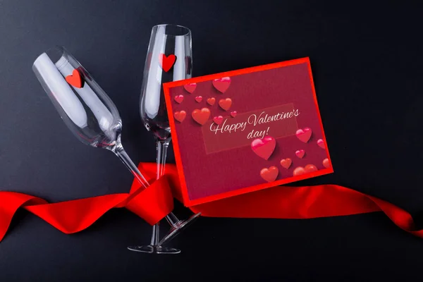 Valentýn Dárková Karta Flétny Šampaňského Zabalené Červenou Stuhou Černém Stole — Stock fotografie