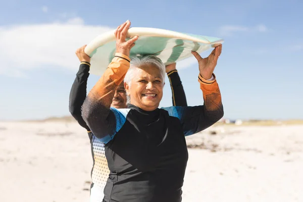Happy Multiracial Senior Woman Carrying Surfboard Together Man Sunny Beach — Stock Photo, Image
