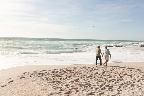 在阳光充足的海滩边手牵手散步的长大成人多种族夫妇 生活方式 爱情和周末 — 图库照片