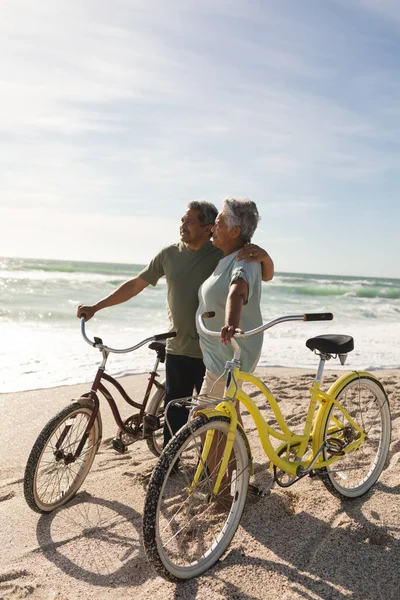 Multiracial Senior Par Tittar Bort Stående Med Cyklar Stranden Mot — Stockfoto