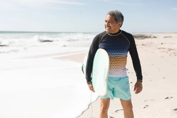 Lachende Biracial Senior Man Houdt Surfplank Weg Kijken Naar Het — Stockfoto