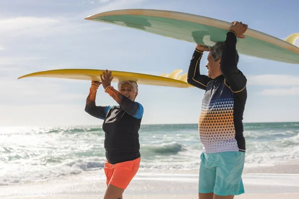 Felice Multirazziale Anziano Coppia Guardando Altro Mentre Trasporta Tavole Surf — Foto Stock