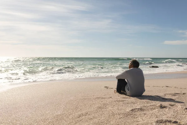 Avslappnad Biracial Senior Man Sitter Stranden Tittar Horisonten Över Havet — Stockfoto