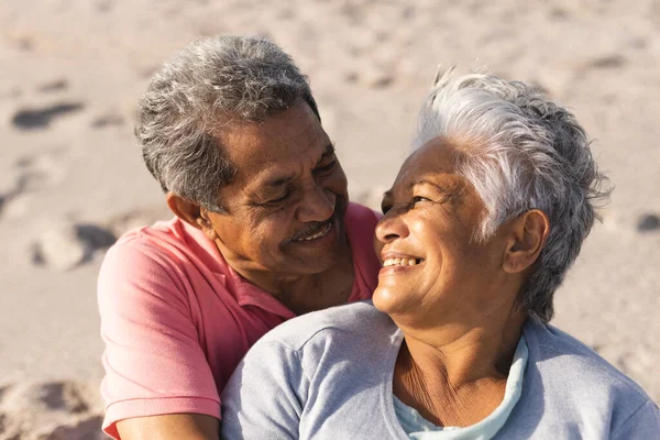 Amar Pareja Ancianos Jubilados Multirraciales Mirándose Mientras Están Sentados Playa — Foto de Stock
