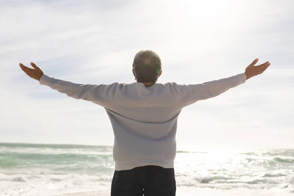 Rear View Biracial Senior Man Arms Outstretched Standing Beach Sunny — Stock Photo, Image