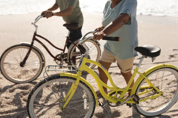 在阳光明媚的日子里 在沙滩上骑自行车散步的夫妇比例较低 积极的生活方式和交通 — 图库照片