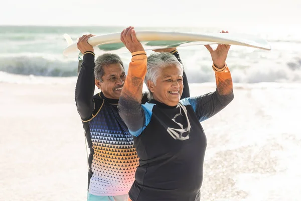 Gelukkig Multiraciaal Seniorenpaar Dat Tijdens Zonnige Dag Surfplank Het Strand — Stockfoto