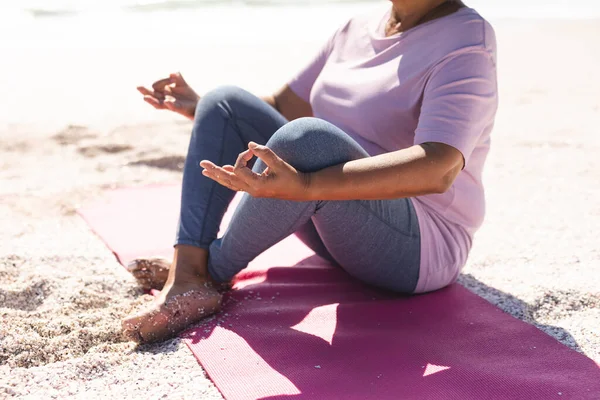 Sección Baja Mujer Birracial Mayor Meditando Posición Loto Playa Día —  Fotos de Stock