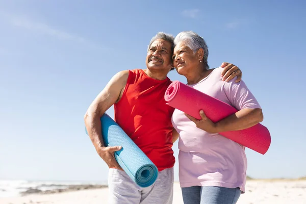 Happy Senior Biracial Couple Holding Yoga Mats Looking Away Beach — Stock Photo, Image