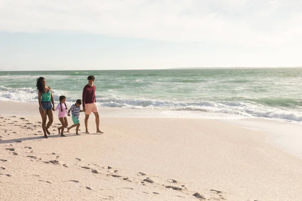 日当たりの良いビーチで足跡で海岸を歩く多人種家族の完全な長さ ライフスタイル愛週末 — ストック写真