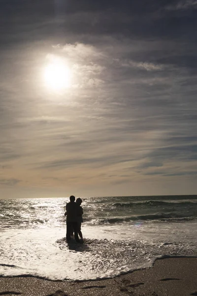 다년간의 부부는 해변에서 하늘을 배경으로 파도를 즐긴다 — 스톡 사진