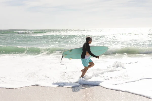 Widok Boku Starszego Człowieka Niosącego Deskę Surfingową Plaży Słoneczny Dzień — Zdjęcie stockowe