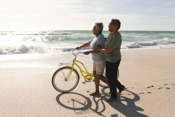 Vista Lateral Casal Idosos Multirraciais Caminhando Com Bicicleta Praia Durante — Fotografia de Stock