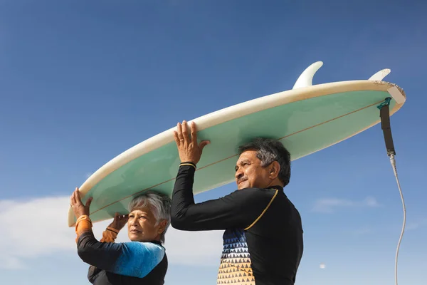 Low Angle View Van Multiraciaal Senior Koppel Dat Surfplank Hoofden — Stockfoto