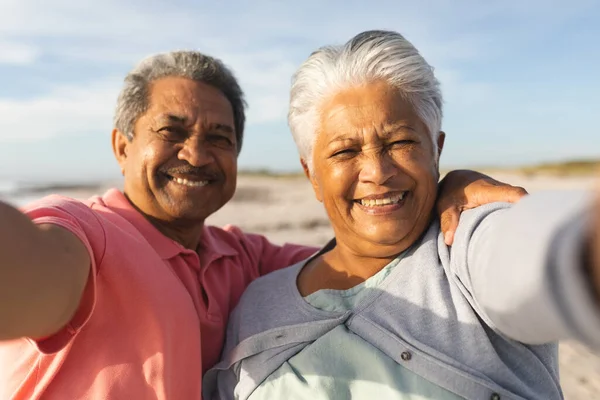 ビーチで自撮りしながら引退を楽しむ多人種シニアカップルの笑顔の肖像画 ライフスタイル愛週末 — ストック写真
