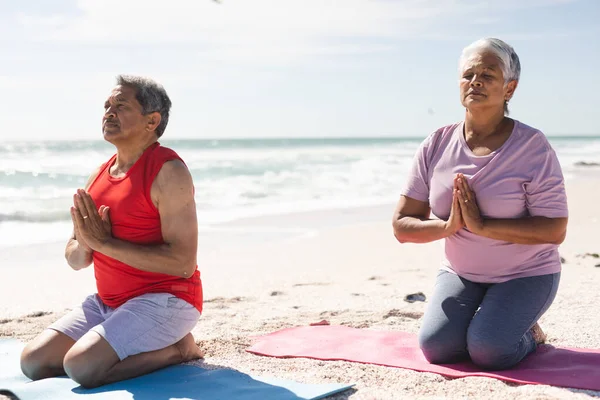 年龄较大的夫妇在海滩练习瑜伽时 双目紧闭 双膝跪在练习垫上 积极的生活方式和健身 — 图库照片