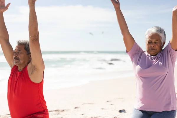 在阳光明媚的日子里 一对年长的白垩纪夫妇抱着胳膊在海滩上对着天空锻炼 积极的生活方式和健身 — 图库照片