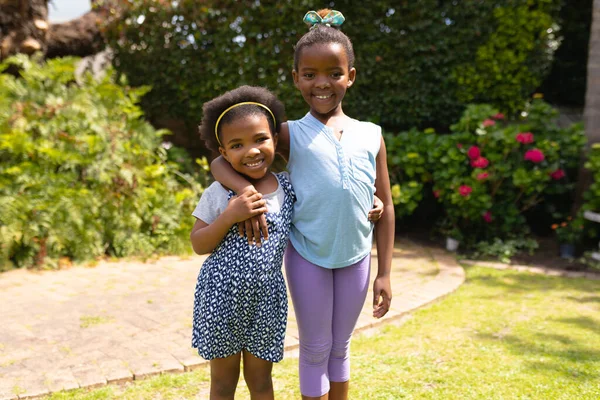 Retrato Una Niña Afroamericana Sonriente Pie Con Brazo Alrededor Hermana —  Fotos de Stock