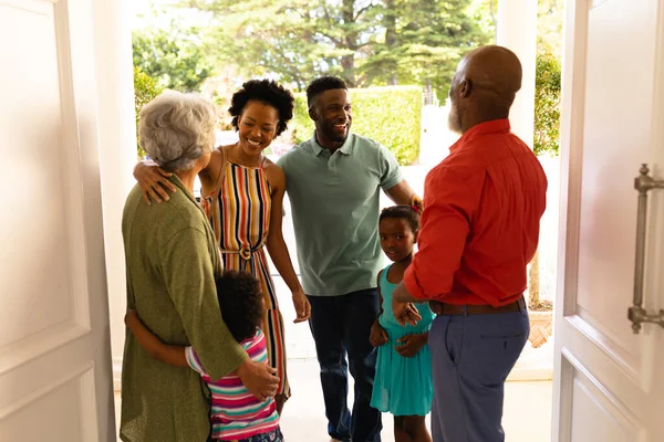 アフリカ系アメリカ人のシニアカップルは 家の正面玄関に立って家族を歓迎します 家族愛と団結の概念を変えずに — ストック写真