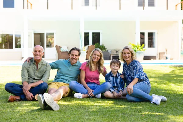 Retrato Família Caucasiana Três Gerações Sorrindo Enquanto Sentados Juntos Jardim — Fotografia de Stock