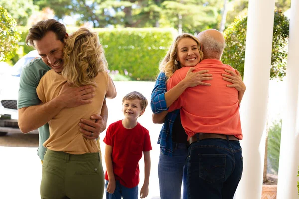 Visão Traseira Casal Idosos Caucasianos Abraçando Sua Família Entrada Casa — Fotografia de Stock