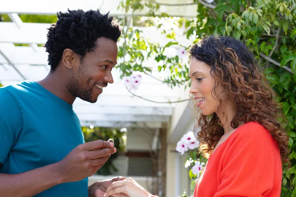 アフリカ系アメリカ人の男性が庭に輪を持つ出産のガールフレンドを提案笑顔 人と愛と団結の概念を変えずに — ストック写真