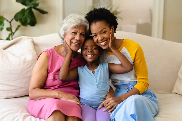 アフリカ系アメリカ人の祖母 孫娘の肖像画が自宅のソファに座って笑っている 家族愛と団結の概念を変えずに — ストック写真