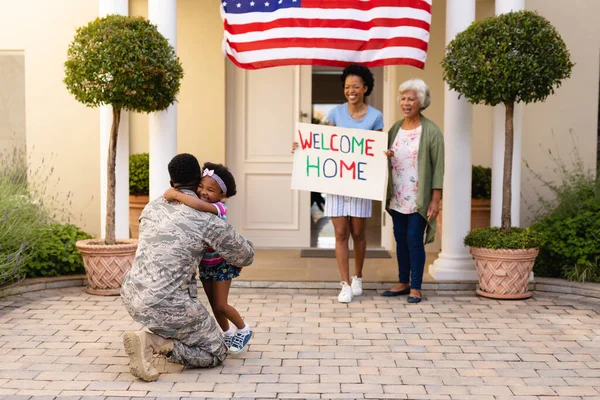 微笑着的非洲裔美国女人看着女孩抱着父亲的士兵在门口回家 团结和爱国主义 — 图库照片
