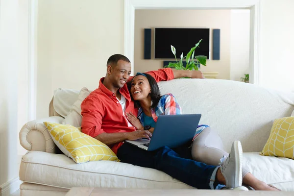 Leende Ungt Afrikanskt Amerikanskt Par Liggande Soffan Med Laptop Vardagsrummet — Stockfoto