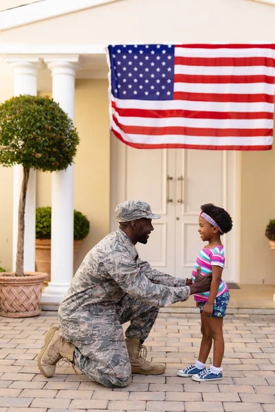 アフリカ系アメリカ人の男性兵士が家の入り口で娘に挨拶をする 家族と絆と愛国心は変わらず — ストック写真