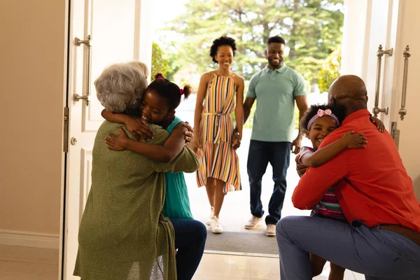 非洲裔美国女孩在家里的前门拥抱她们的祖父母 爱情和融合概念 — 图库照片