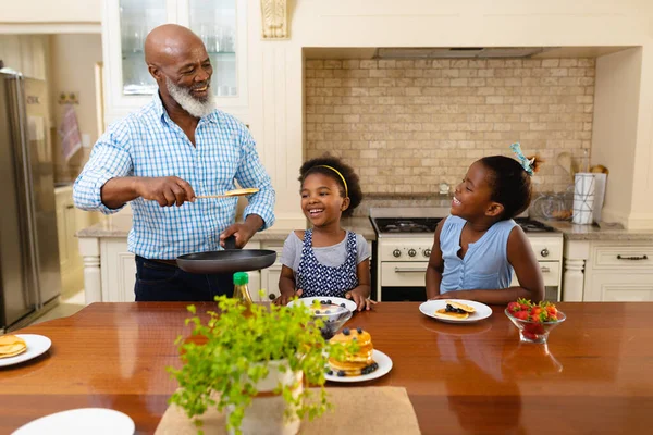 Abuelo Afroamericano Que Sirve Desayuno Para Sus Dos Nietas Cocina —  Fotos de Stock