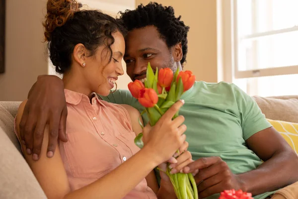 Hombre Afroamericano Sentado Con Brazo Alrededor Novia Biracial Sosteniendo Tulipanes —  Fotos de Stock