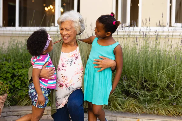 Afro Amerikaanse Oma Kijkt Naar Haar Kleindochters Glimlacht Buiten Familie — Stockfoto